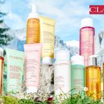 Man sieht eine natürliche Landschaft in den Schweizer Alpen mit den Produkten aus der neuen Reinigungslinie von Clarins im Vordergrund des Bildes.