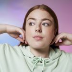 young female model pushing hair behind shoulders