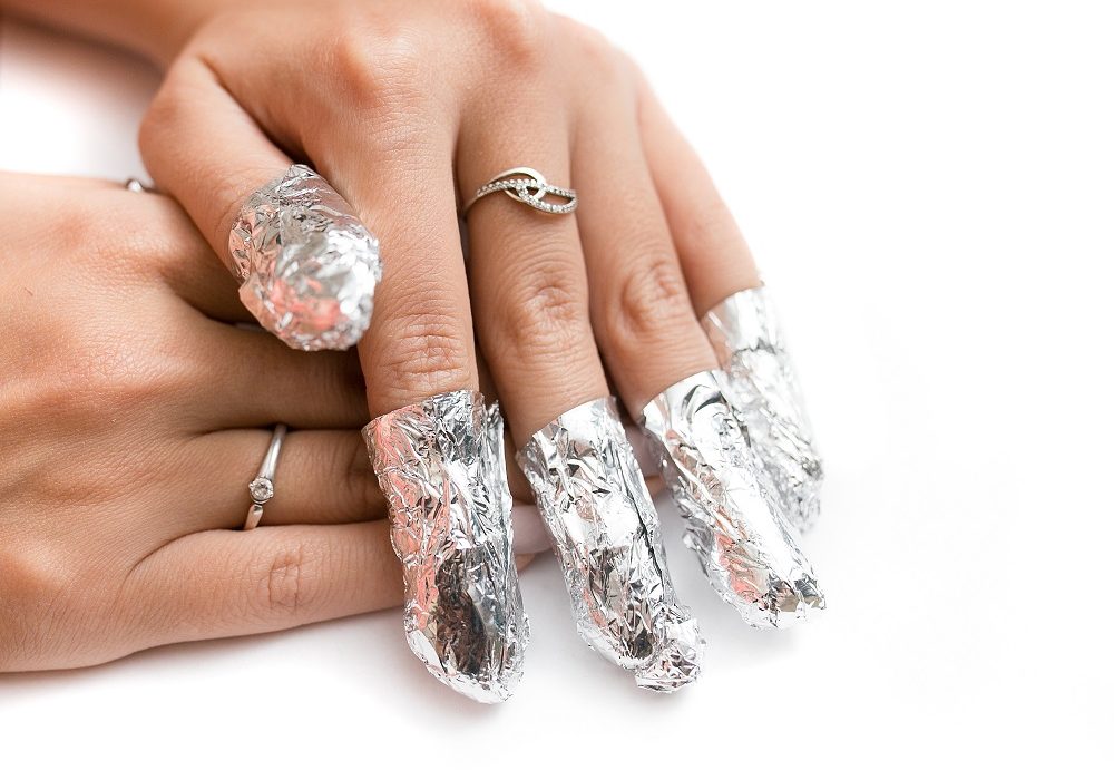 Removal of gel nail polish using a foil. Isolated on white.