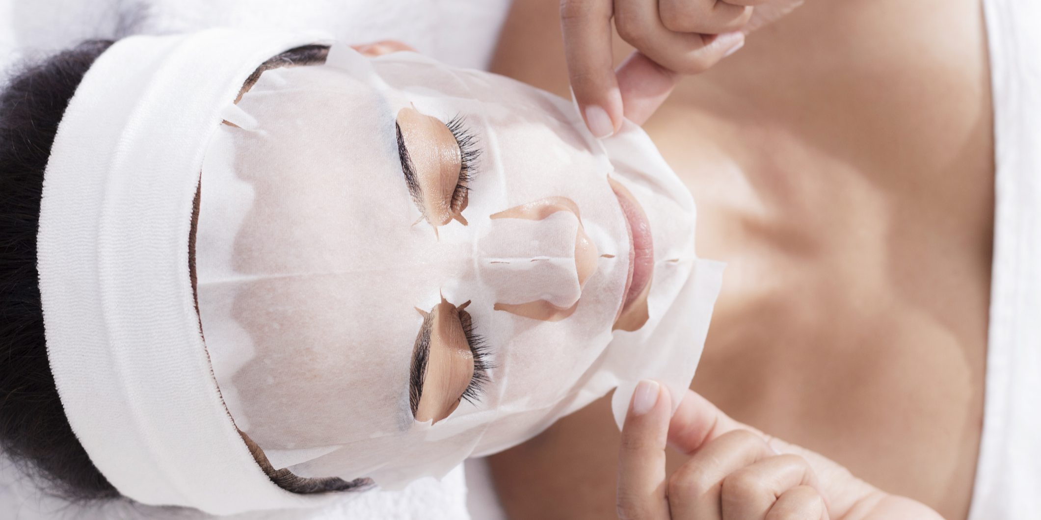 Woman in beauty spa is using facial mask as beauty product.