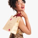 Female model holding MRD christmas shopping bag over shoulder