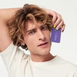 blonde male holding the new loyality card
