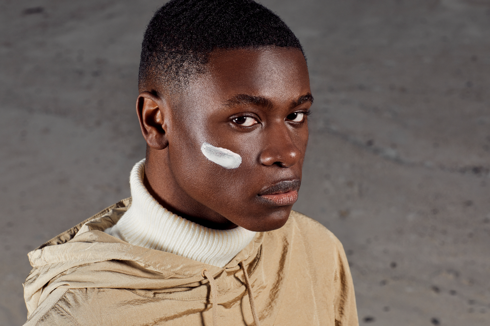 male model with moisturiser on cheek