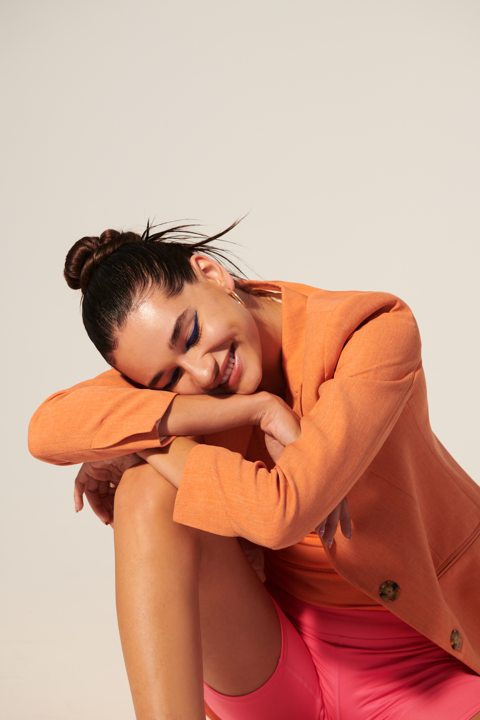 female resting her head on her knee and laughing