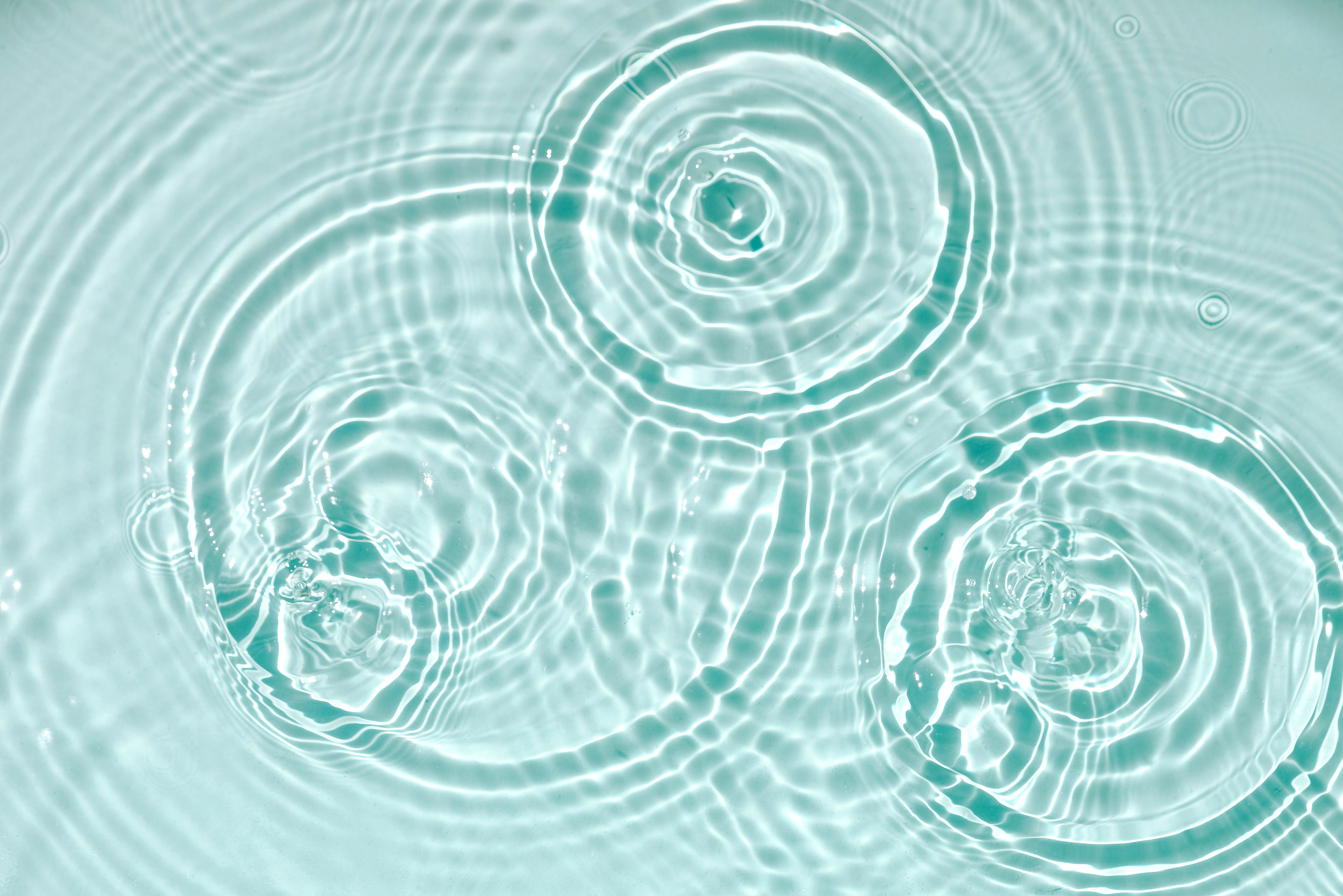 Blue water texture, blue mint water surface with rings and ripples. Spa concept background. Flat lay, copy space. Water background. Blue water texture, blue mint water surface with rings and ripples. Spa concept background. Flat lay, top view, copy space.