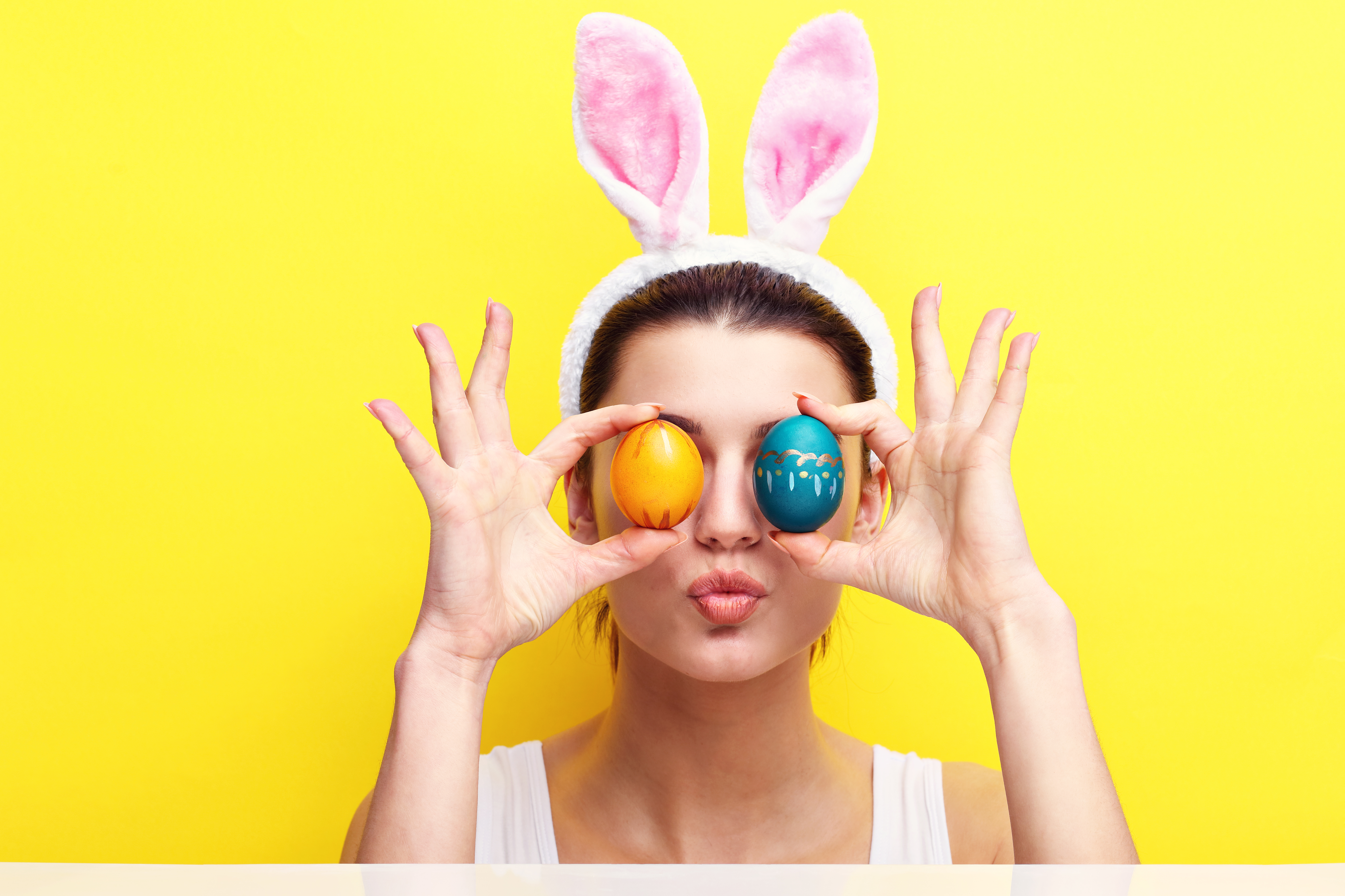Studio shot of a happy young woman wearing bunny ears