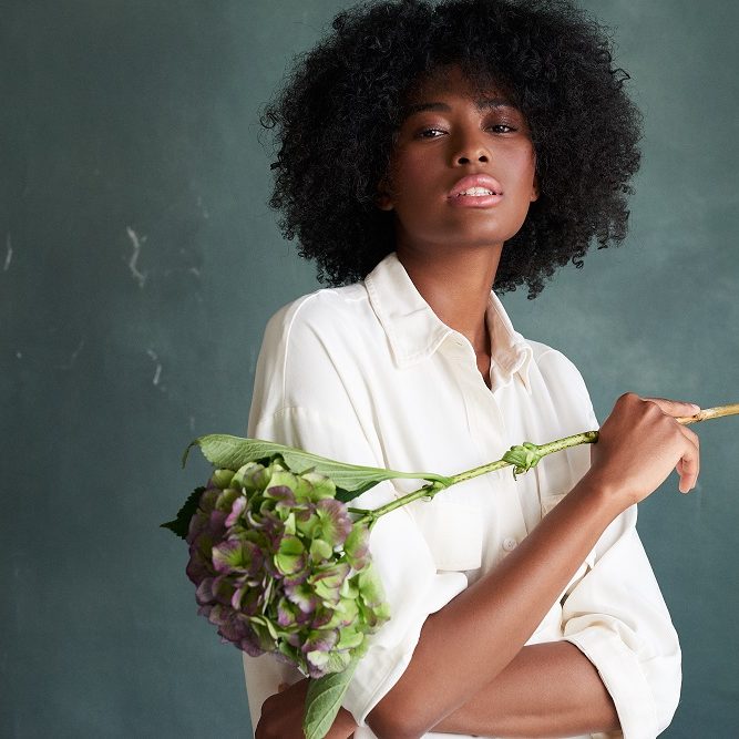 female model holding a flower