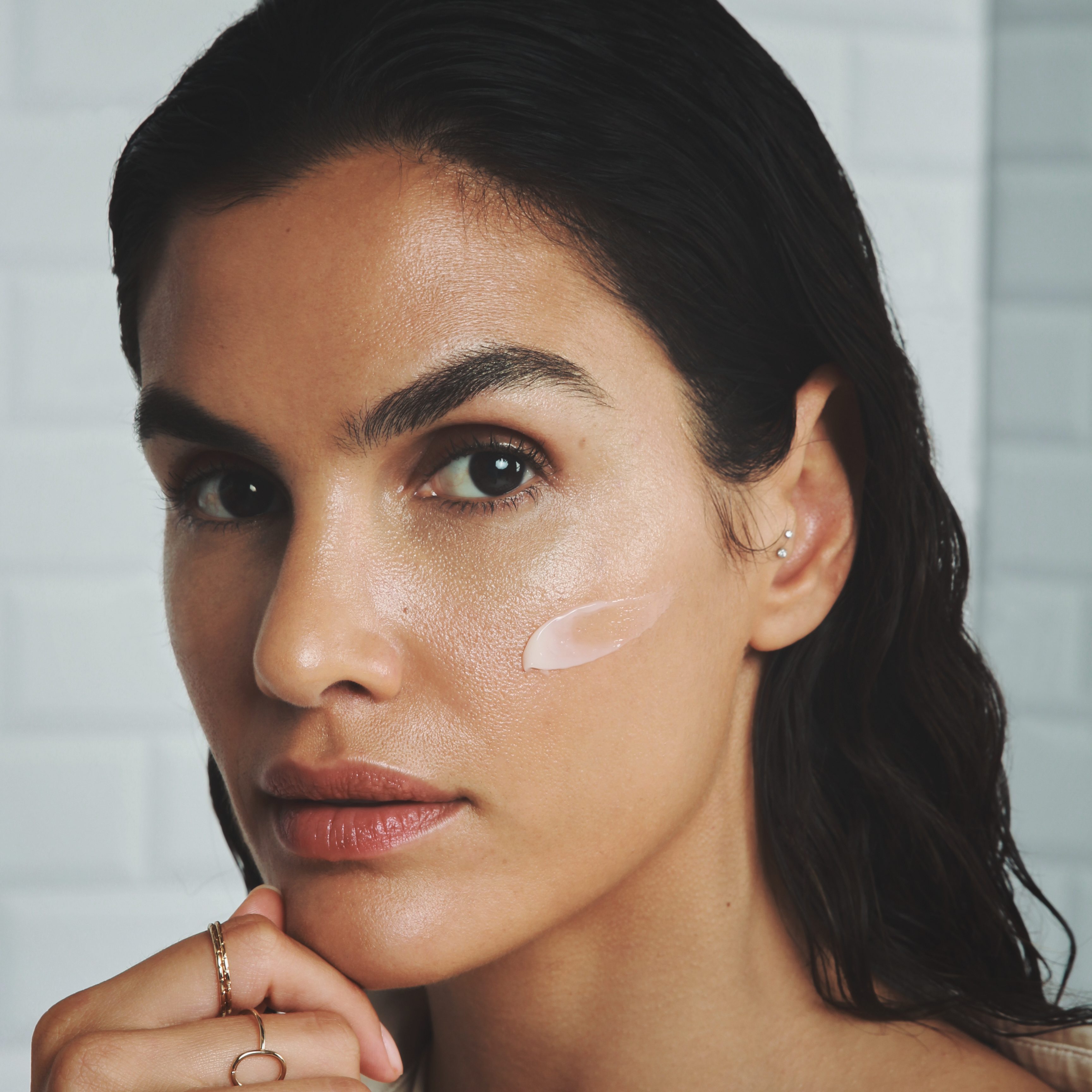 female model with cream product on her cheekbone