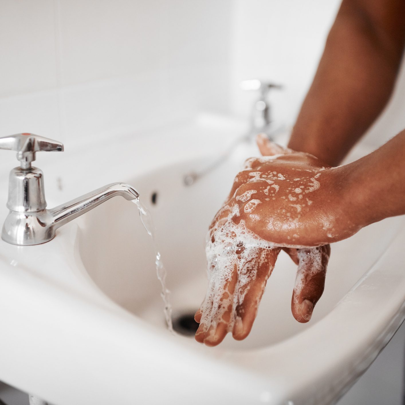 Cropped shot of an unrecognizable man washing his hands in the bathroom at home