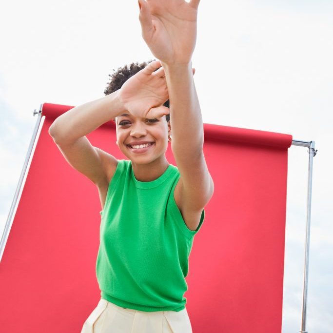 female model with arms up smiling