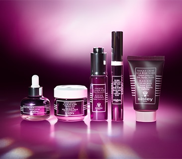 Sisley Rose Noire Pflegeroutine mit Serum, Creme und Maske, arrangiert vor einem roséfarbenen Hintergrund.
